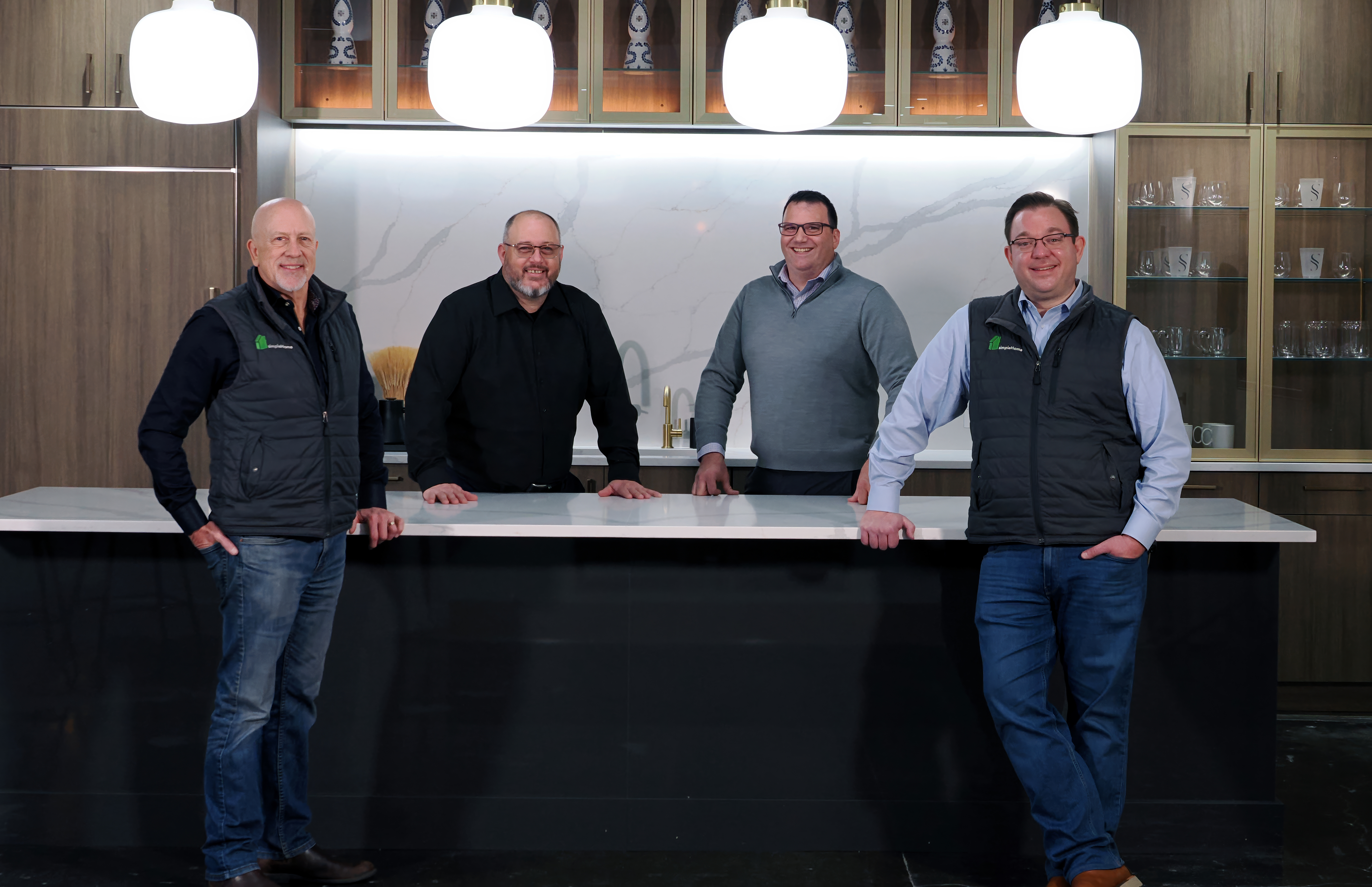 Two men standing next to a sign for a Wednesday breakfast event in a bright, outdoor setting.