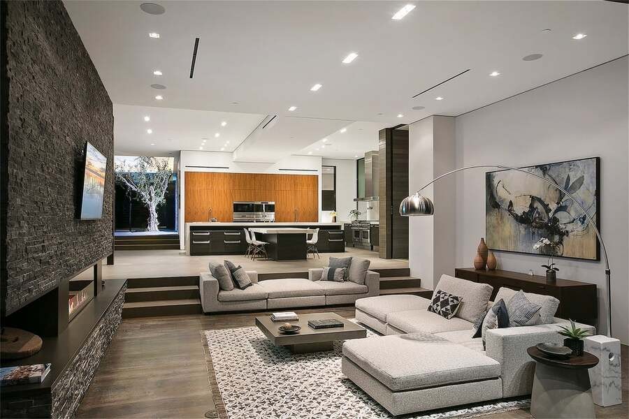 A luxury living room with a large TV and in-ceiling speakers on the ceiling.