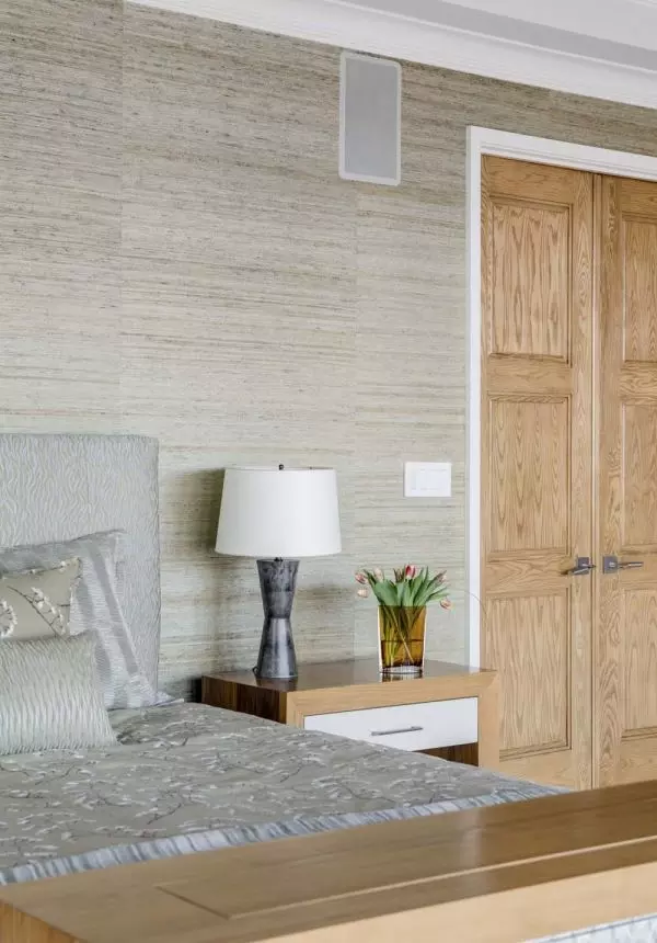 Beige wall with lamp, flower vase, and wooden doors