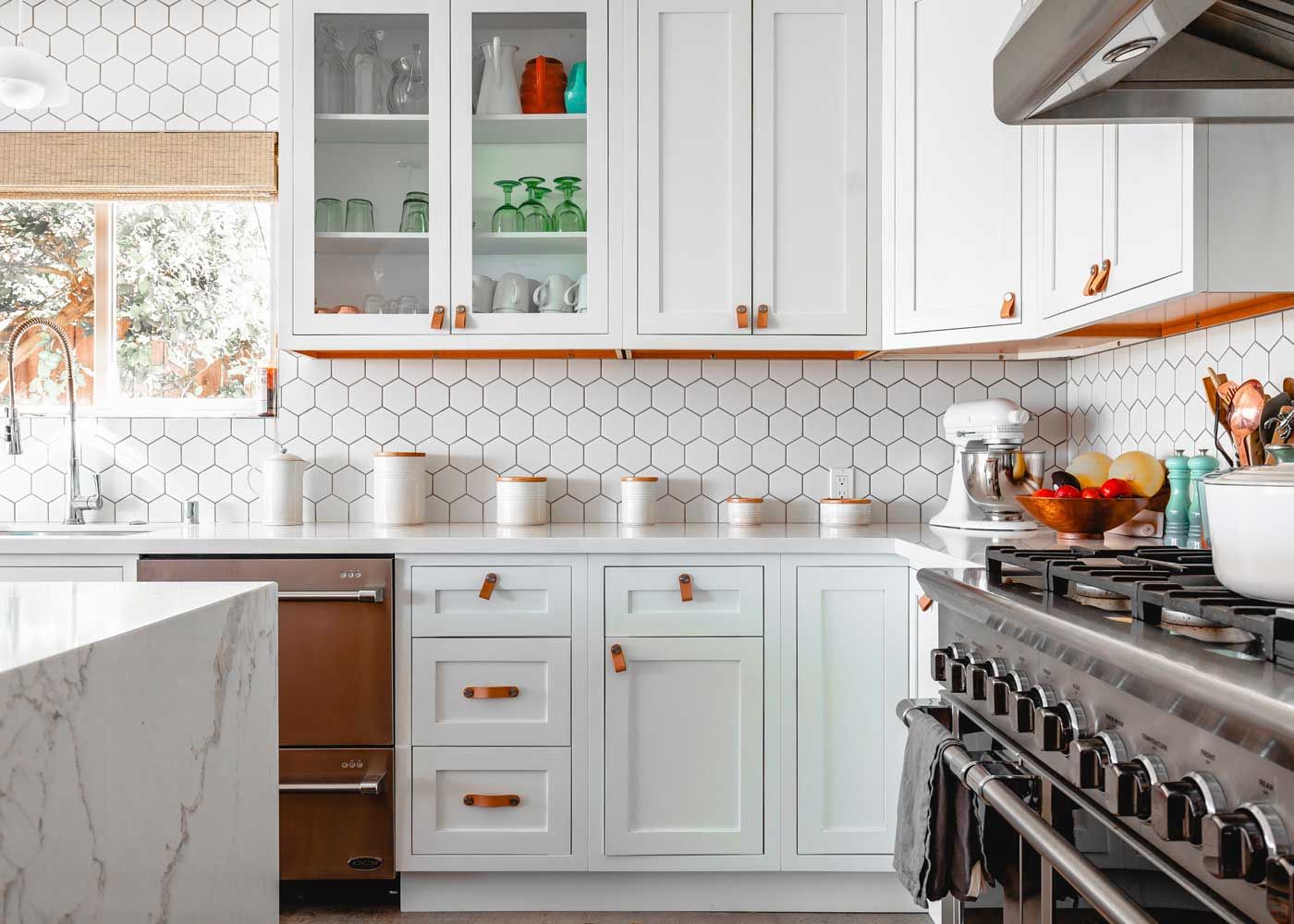 View of kitchen with white tiling and white cabinets