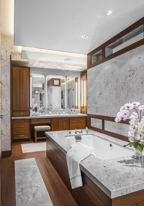 wooden flooring and cabinets in a marble bathroom