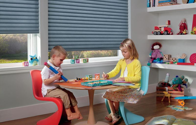 Kids playing at table with blinds behind them